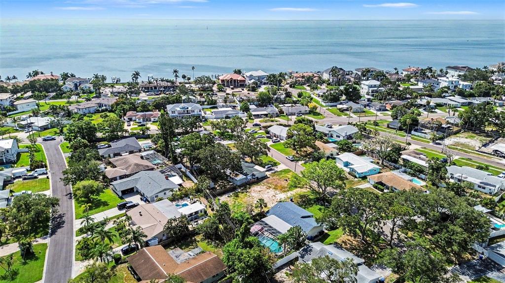 An aerial view shows a coastal neighborhood with houses, trees, and a large body of water — 1737 COLORADO AVENUE NE, ST PETERSBURG, FL