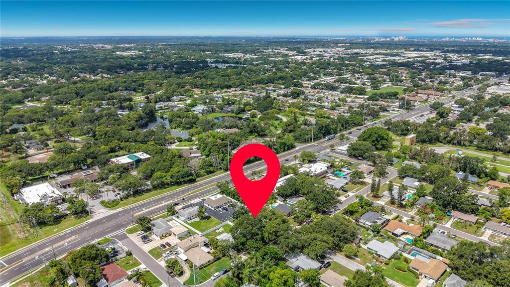 An aerial view shows a red map pin marking a property surrounded by suburban trees — 2471 RAYMONT DRIVE, CLEARWATER, FL