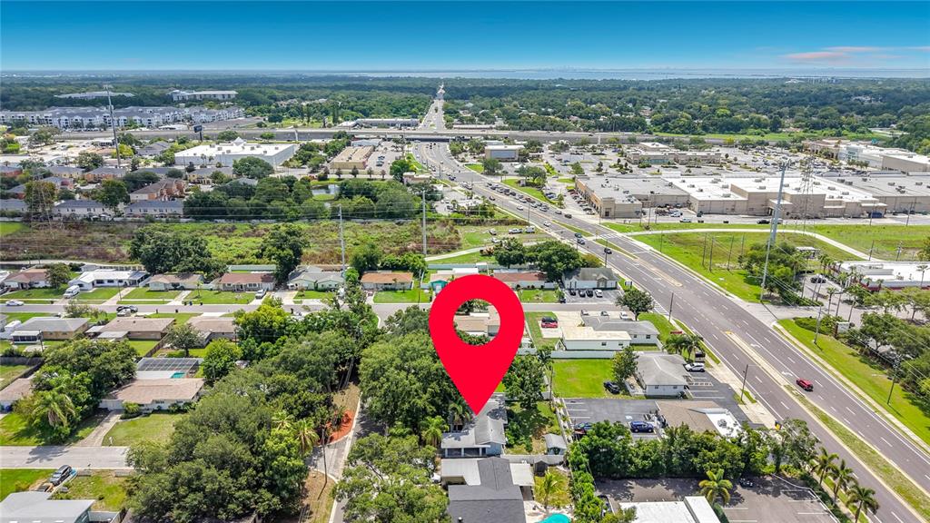 An aerial view shows a residential property marked with a red pin near a highway — 2471 RAYMONT DRIVE, CLEARWATER, FL