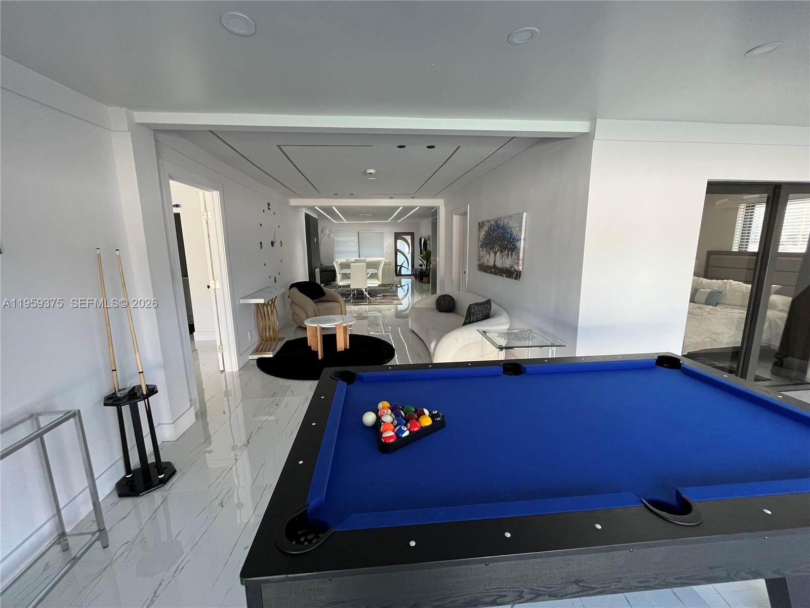 A room features a blue pool table, white marble floors, and a seating area — 39 SE 7th St # 0, Dania Beach FL 33004, DANIA BEACH, FL