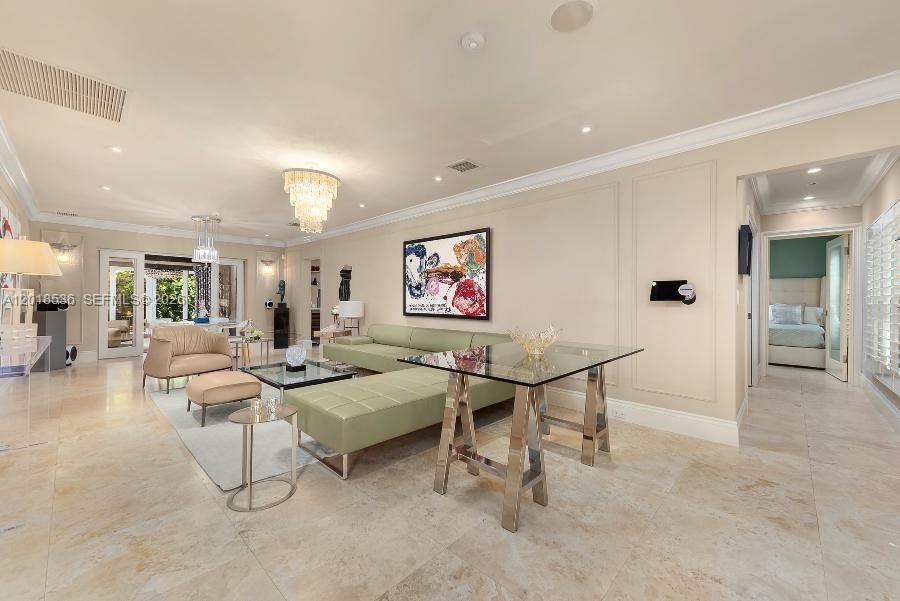 A spacious living room features a green sectional sofa, glass tables, and tile flooring — 830 E Dilido Dr, Miami Beach FL 33139, MIAMI BEACH, FL
