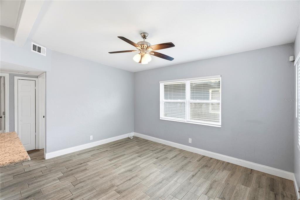 An empty room with gray walls, wood-look tile flooring, and a ceiling fan — 3219 40TH STREET N, ST PETERSBURG, FL