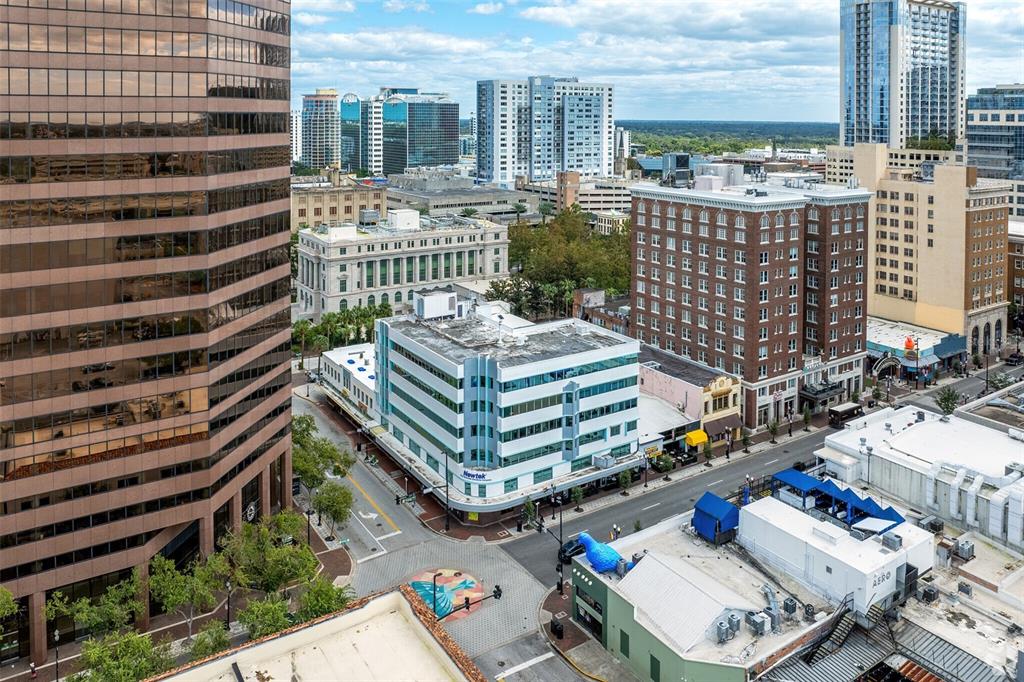 An elevated view of a city street corner featuring a modern office building and skyscrapers — 14 E WASHINGTON STREET, ORLANDO, FL