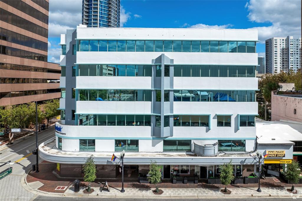 A multi-story white office building with horizontal windows and a ground-floor smoke shop — 14 E WASHINGTON STREET, ORLANDO, FL