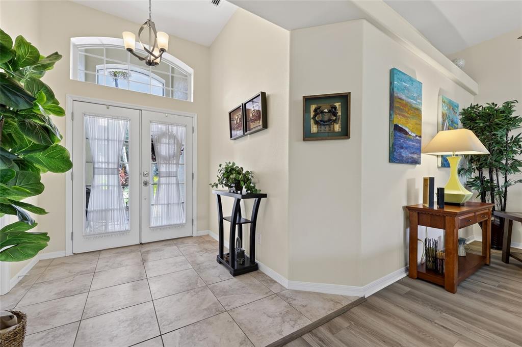 An entryway features tile flooring, a double front door with a transom window, and decor — 318 LANGHOLM DRIVE, VENICE, FL