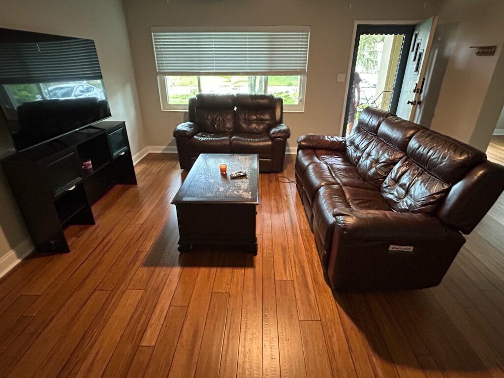 A living room features dark leather furniture, a wooden coffee table, and hardwood flooring — 6120 9th Avenue S, FL 33707, FL