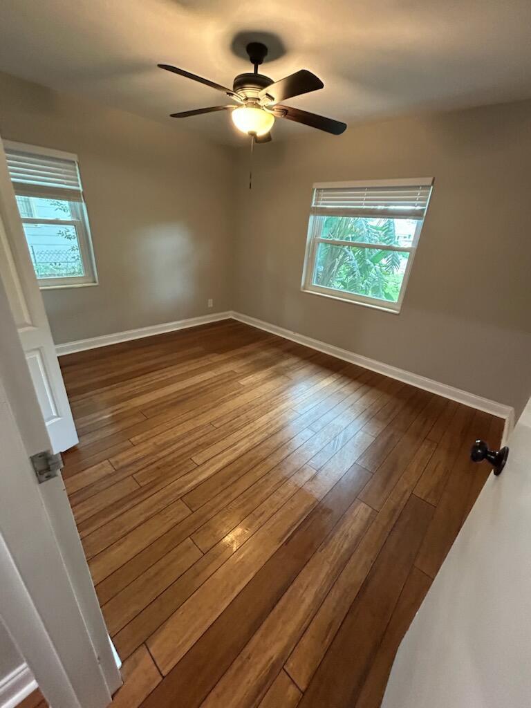 An empty bedroom with hardwood floors, a ceiling fan, and two windows with blinds — 6120 9th Avenue S, FL 33707, FL