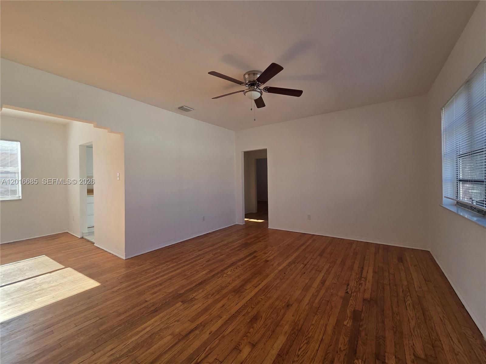 An empty room features hardwood floors, white walls, a ceiling fan, and two windows — 781 SW 11th St # 3, Miami FL 33129, MIAMI, FL