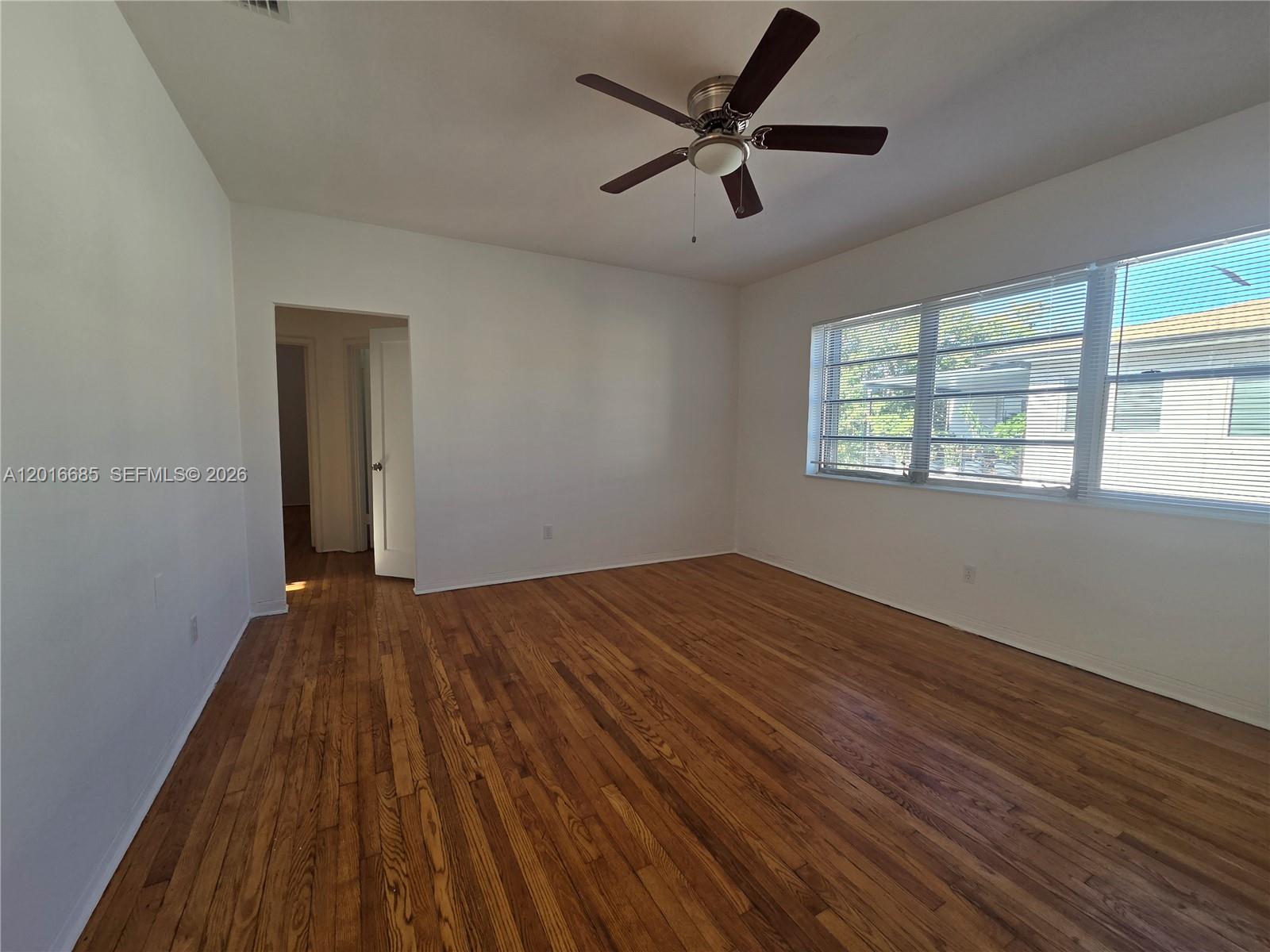 An empty bedroom features hardwood floors, white walls, a ceiling fan, and large windows — 781 SW 11th St # 3, Miami FL 33129, MIAMI, FL