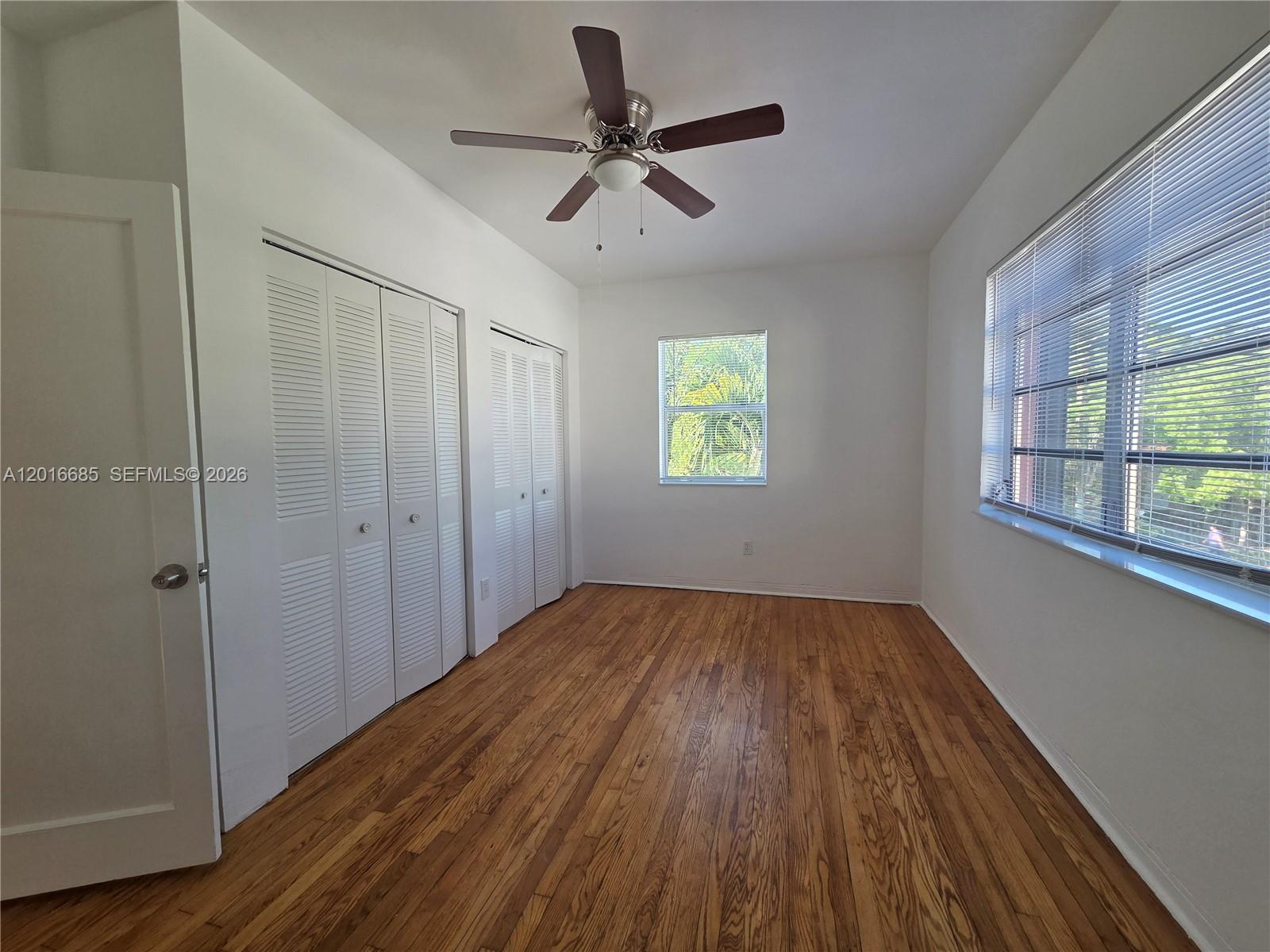 An empty bedroom features white walls, hardwood floors, a ceiling fan, and louvered closet doors — 781 SW 11th St # 3, Miami FL 33129, MIAMI, FL