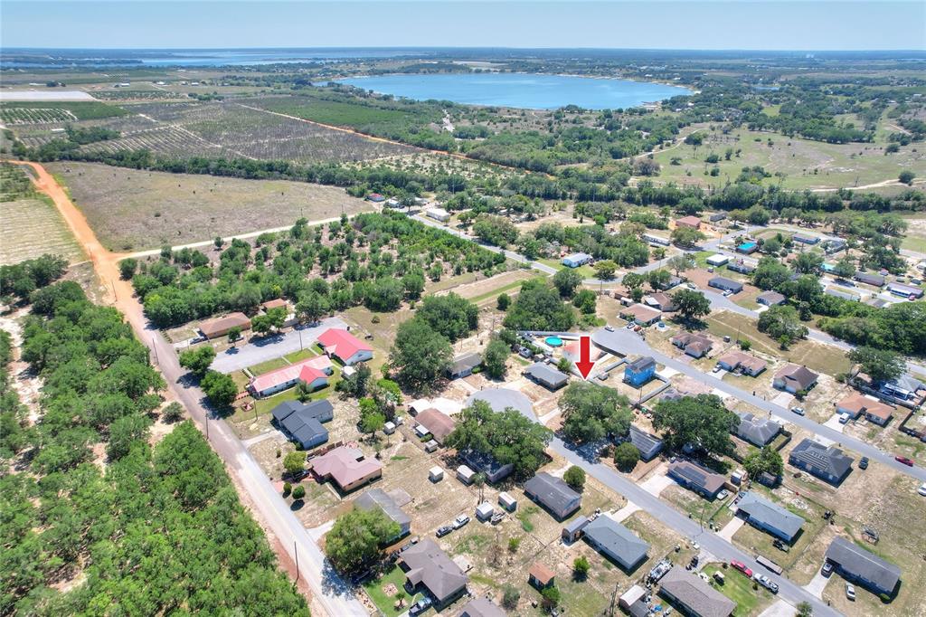 An aerial view shows a residential neighborhood with a red arrow pointing to a house — 1554 SARAH STREET, LAKE WALES, FL