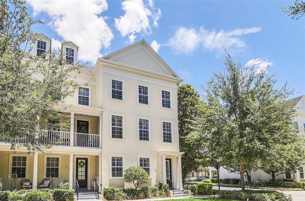 A three-story yellow townhouse with white trim, a front porch, and a balcony — 1579 CHATFIELD PLACE, ORLANDO, FL