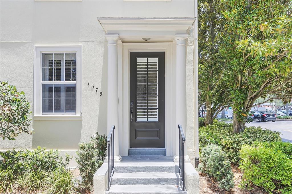 A front entrance with a dark door, white columns, and steps leading to the house — 1579 CHATFIELD PLACE, ORLANDO, FL