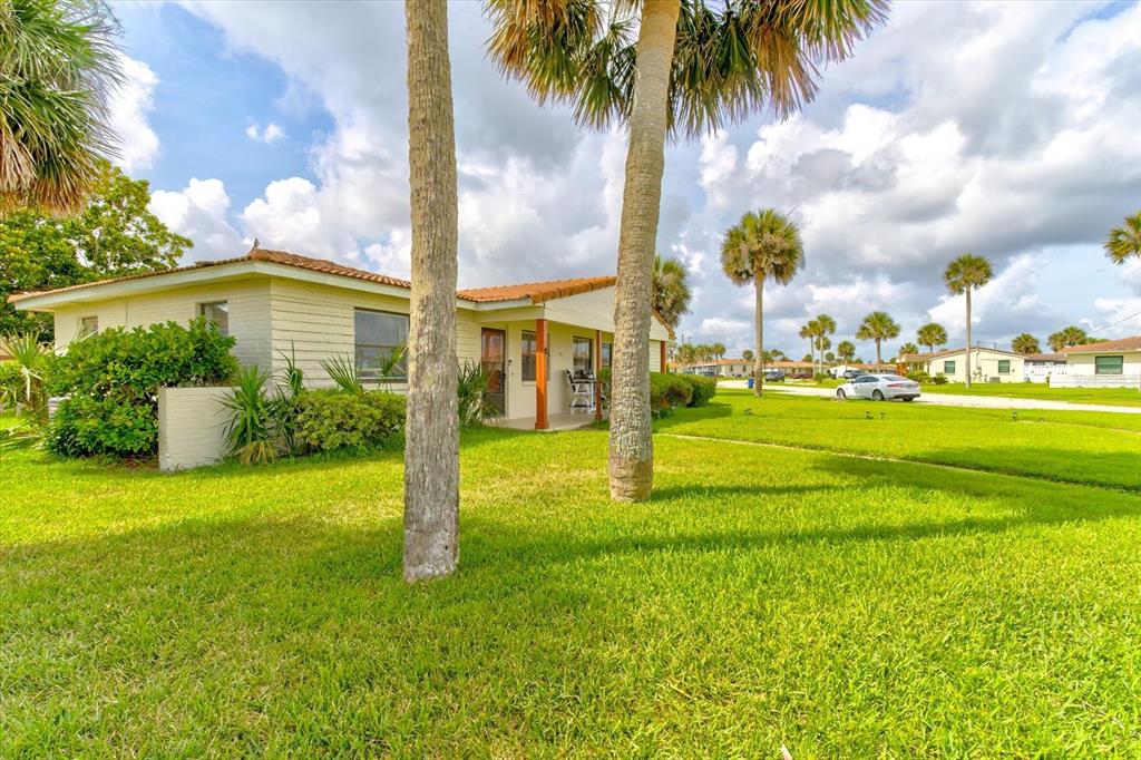 A single-story house with a tiled roof sits on a grassy lot with palm trees — 232 NORTHSHORE DRIVE UNIT A & #B, ORMOND BEACH, FL