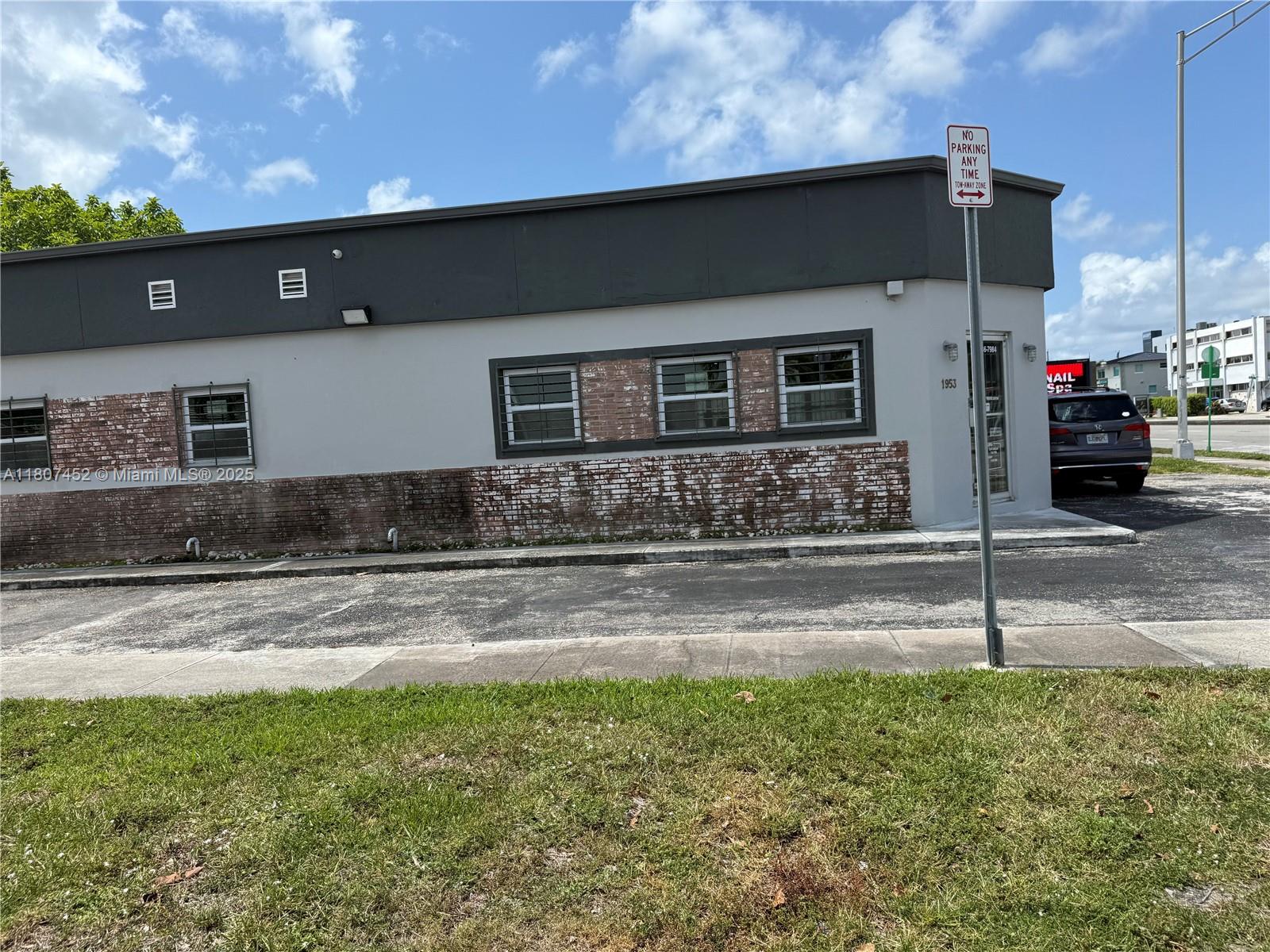 A single-story commercial building features a gray facade with brick accents and security bars — 1953 SW 27th Ave, Miami FL 33145, MIAMI, FL