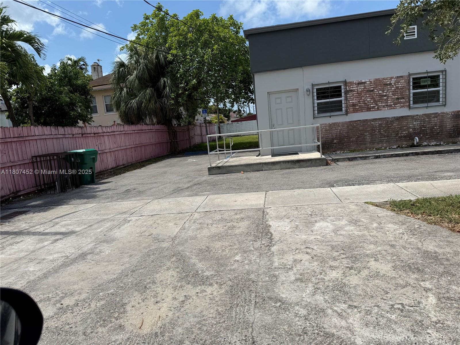 A concrete parking area leads to a building entrance with a ramp and metal railing — 1953 SW 27th Ave, Miami FL 33145, MIAMI, FL