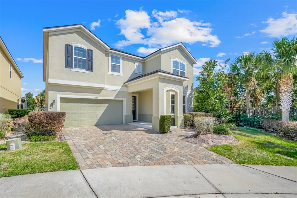 A two-story house with a paved driveway, a two-car garage, and light-colored stucco siding — 9021 SUNSHINE RIDGE LOOP, KISSIMMEE, FL