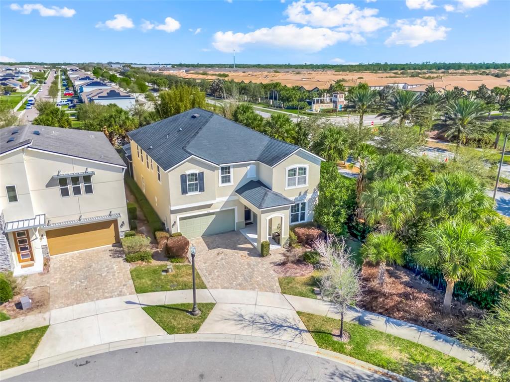 An aerial view shows two suburban houses with paved driveways and palm trees — 9021 SUNSHINE RIDGE LOOP, KISSIMMEE, FL