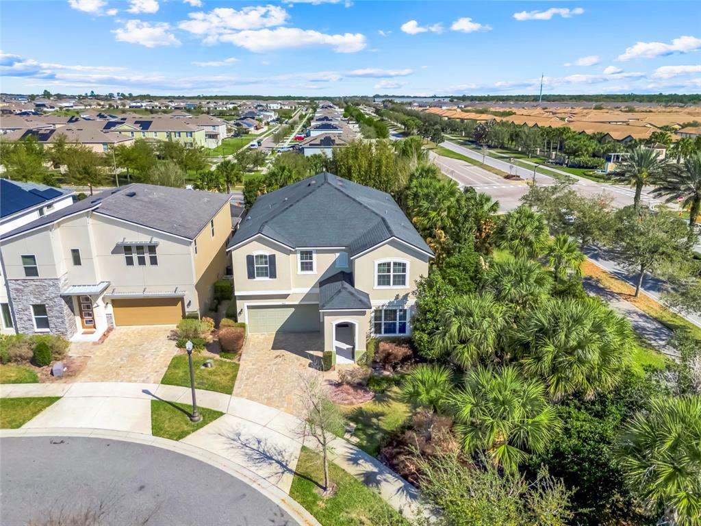 An aerial view shows a two-story suburban house with a paved driveway and palm trees — 9021 SUNSHINE RIDGE LOOP, KISSIMMEE, FL