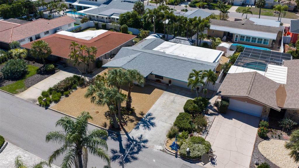 An aerial view of a suburban house with a gray roof, driveway, and palm trees — 290 1ST STREET W, TIERRA VERDE, FL