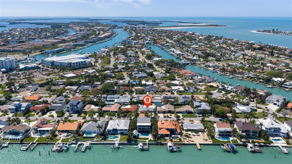 An aerial view shows a waterfront residential neighborhood with a marked house on the canal — 290 1ST STREET W, TIERRA VERDE, FL