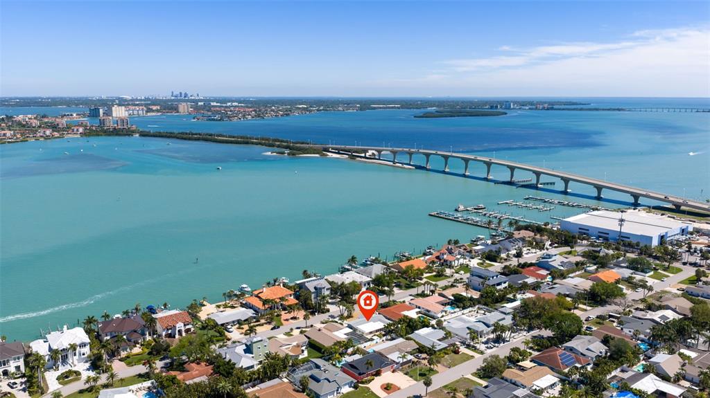 An aerial view shows a waterfront residential neighborhood with a bridge spanning the bay — 290 1ST STREET W, TIERRA VERDE, FL