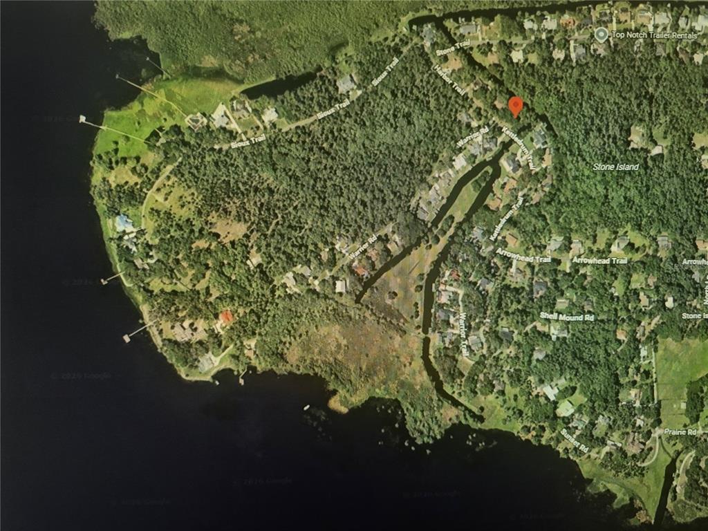 This is an aerial map view of a residential neighborhood surrounded by trees and water — 327 HARBOR TRAIL, DELTONA, FL