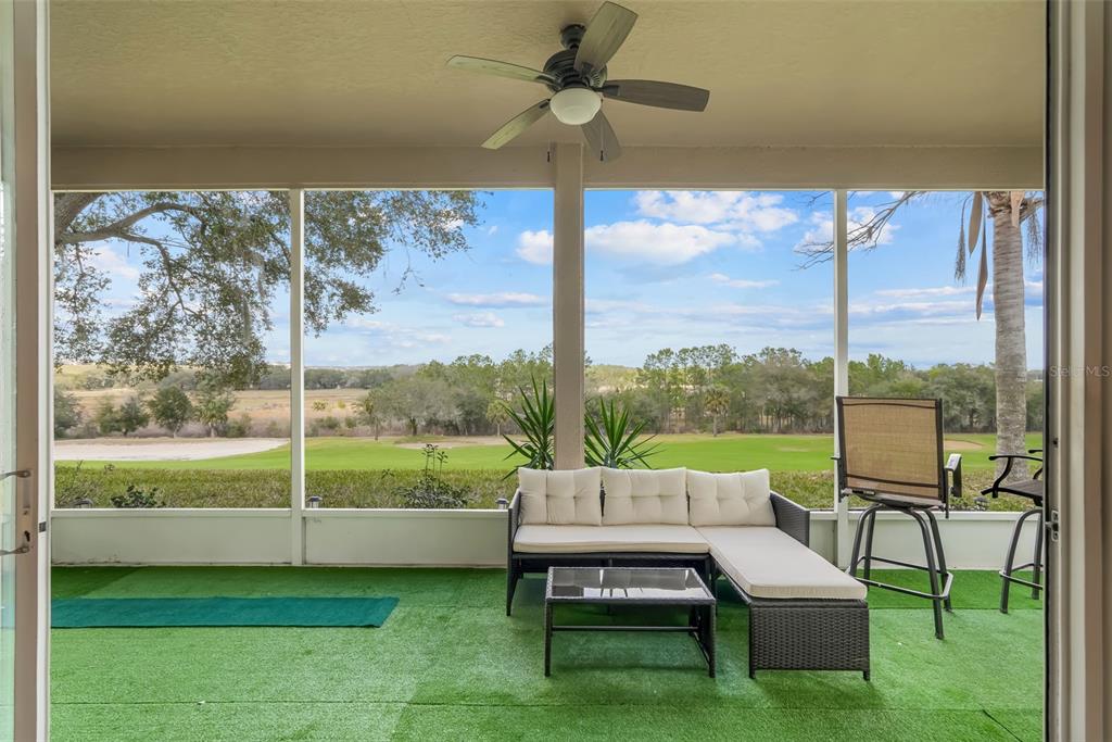 A screened-in patio with artificial turf flooring overlooks a golf course — 2390 CALEDONIAN STREET, CLERMONT, FL