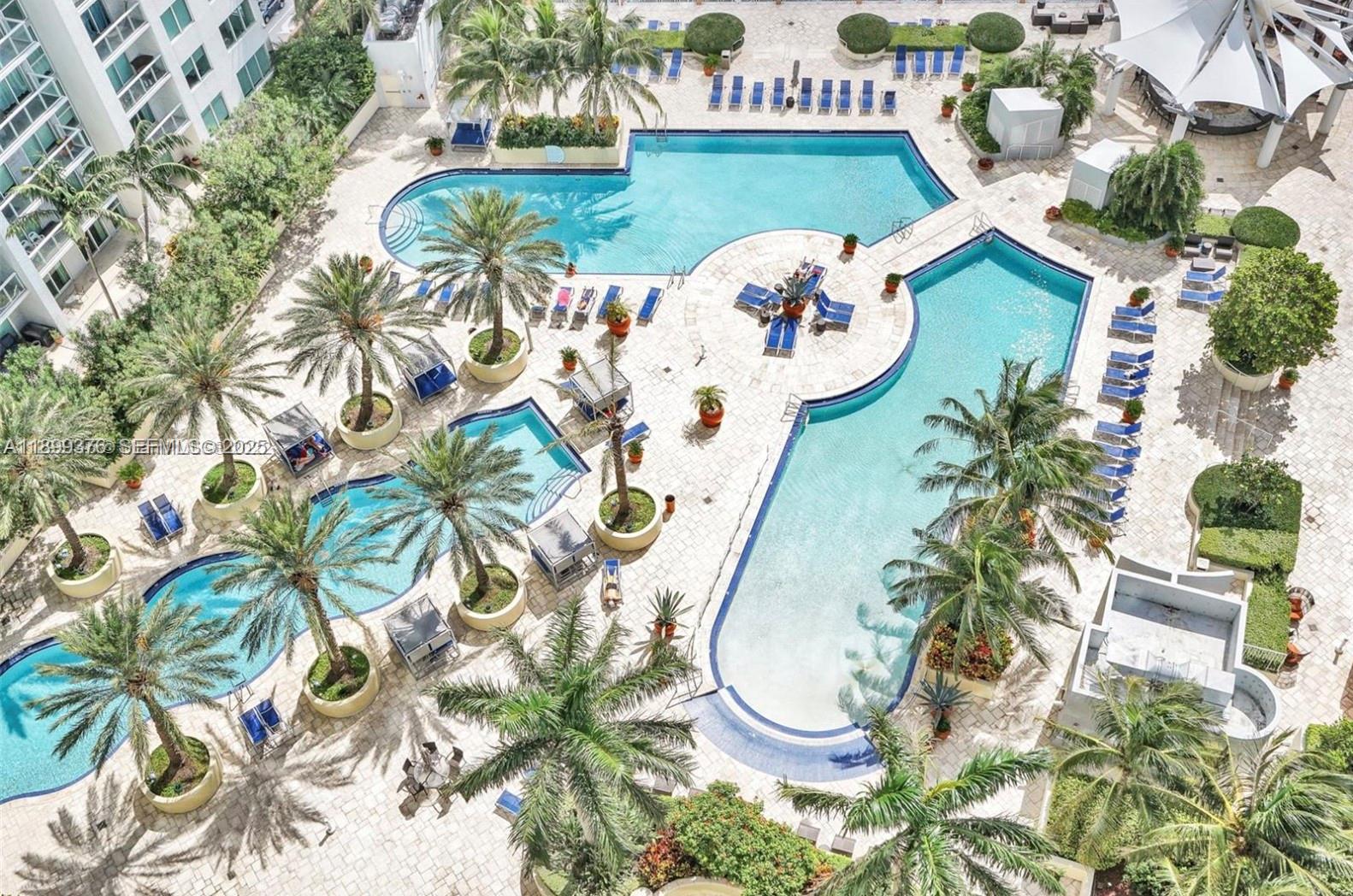 An aerial view shows a resort-style pool complex with multiple connected pools and palm trees — 253 NE 2nd St # 226, Miami FL 33132, MIAMI, FL