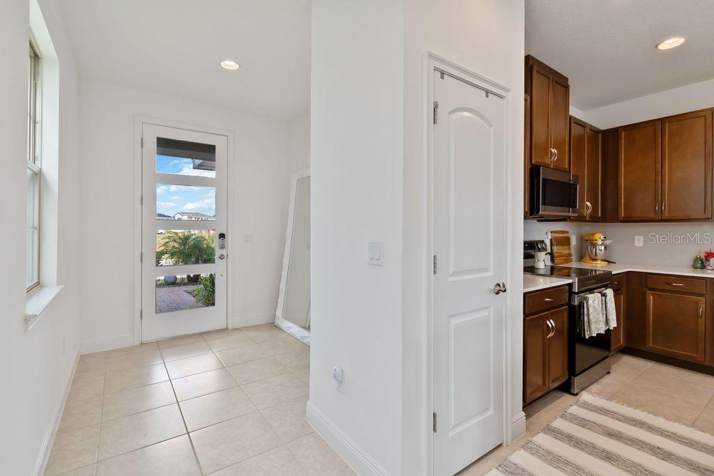 A tiled entryway leads to a kitchen with dark wood cabinets and stainless steel appliances — 3212 OXBOW COURT, HARMONY, FL