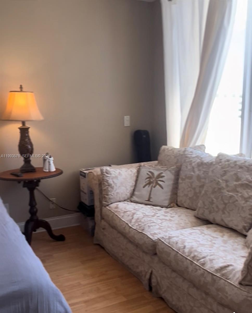 A living room features a beige patterned sofa, a side table with a lamp, and curtains — 1500 S Ocean Dr # 9J, Hollywood FL 33019, HOLLYWOOD, FL