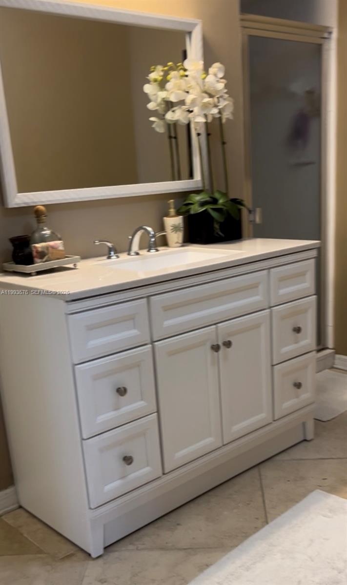 A white bathroom vanity with a sink and mirror sits against a tan wall — 1500 S Ocean Dr # 9J, Hollywood FL 33019, HOLLYWOOD, FL