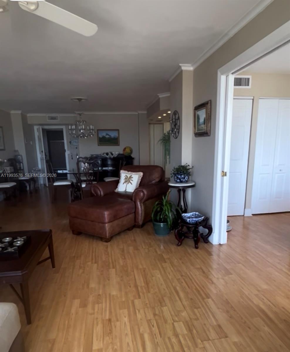 A living room features light wood flooring, a brown leather armchair, and a dining area — 1500 S Ocean Dr # 9J, Hollywood FL 33019, HOLLYWOOD, FL