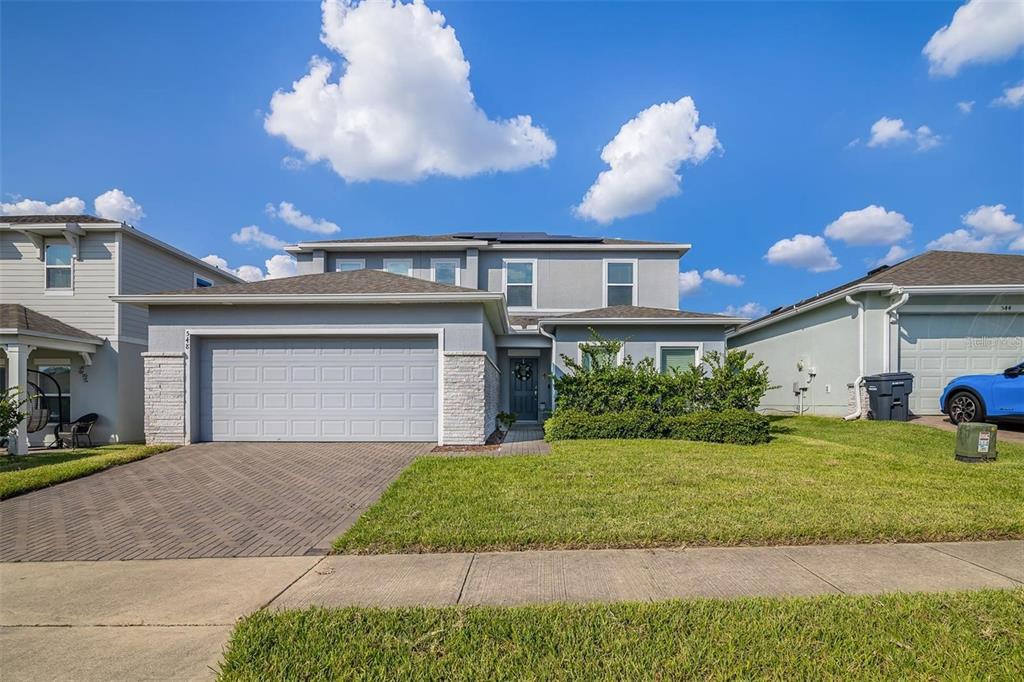 A two-story gray house with a two-car garage and a stone-accented facade — 548 OGELTHORPE DRIVE, DAVENPORT, FL