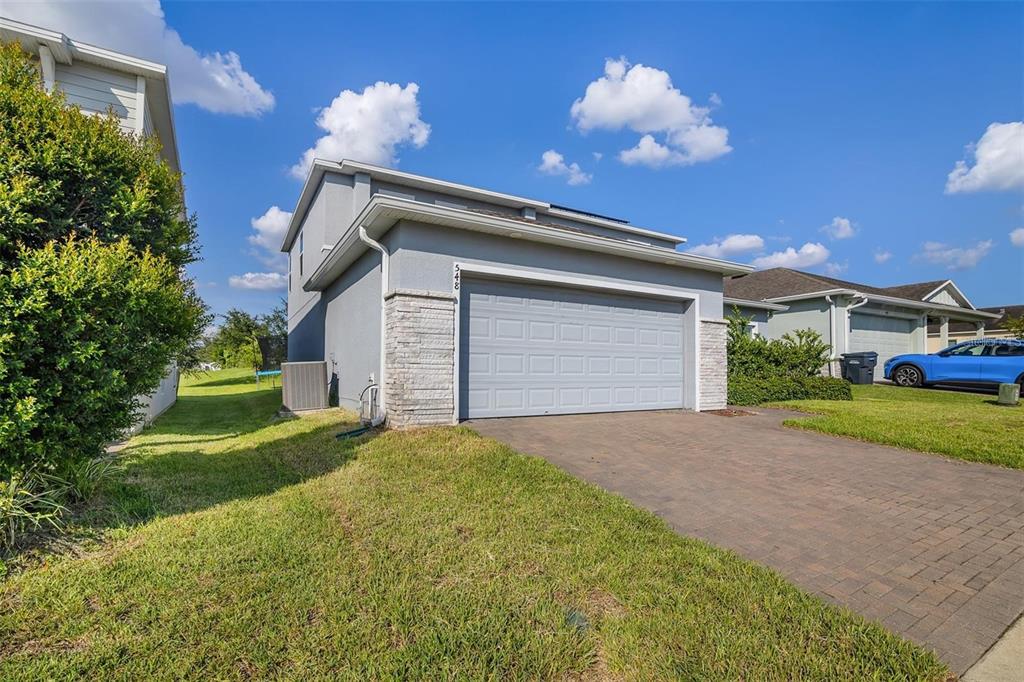 A two-story house with a gray stucco exterior, stone accents, and a two-car garage — 548 OGELTHORPE DRIVE, DAVENPORT, FL