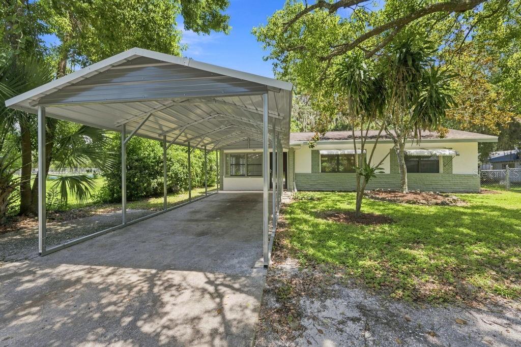 A single-story house with a metal carport and a green and white exterior — 7810 CHAPEL AVENUE, PORT RICHEY, FL
