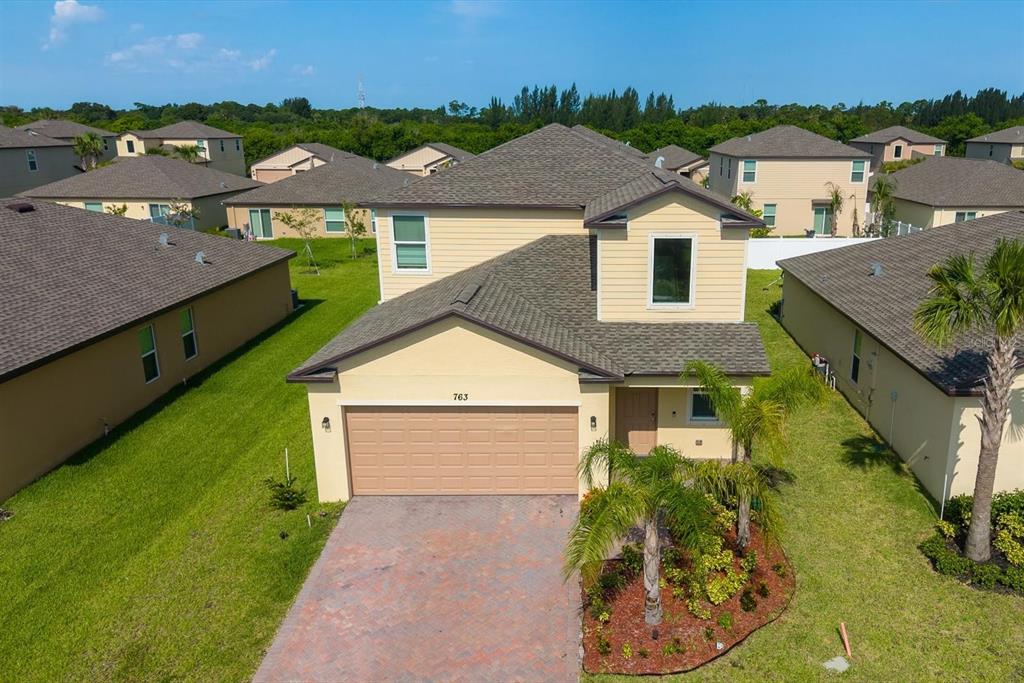 An aerial view of a two-story suburban house with a paved driveway and palm tree — 763 CARLYLE WAY, FORT PIERCE, FL