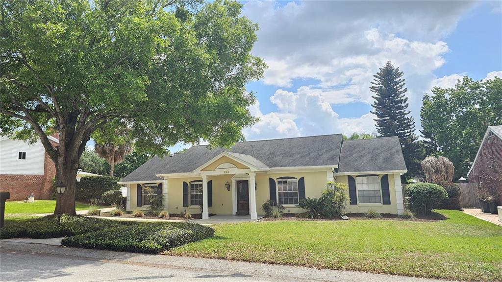 A single-story yellow house with a dark shingled roof and a front porch — 184 LAKE OTIS ROAD, WINTER HAVEN, FL