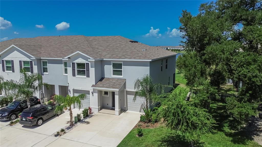 An aerial view shows a two-story gray townhouse with a shingled roof and garages — 331 MANGROVE SHADE CIRCLE, APOLLO BEACH, FL