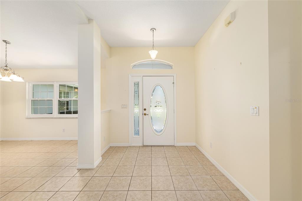 An entryway features a white front door with a glass oval insert and tile flooring — 8601 SW 60TH CIRCLE, OCALA, FL