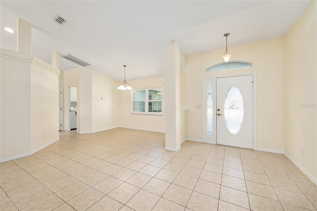 An entryway with tiled floors leads into an open dining area with a chandelier — 8601 SW 60TH CIRCLE, OCALA, FL