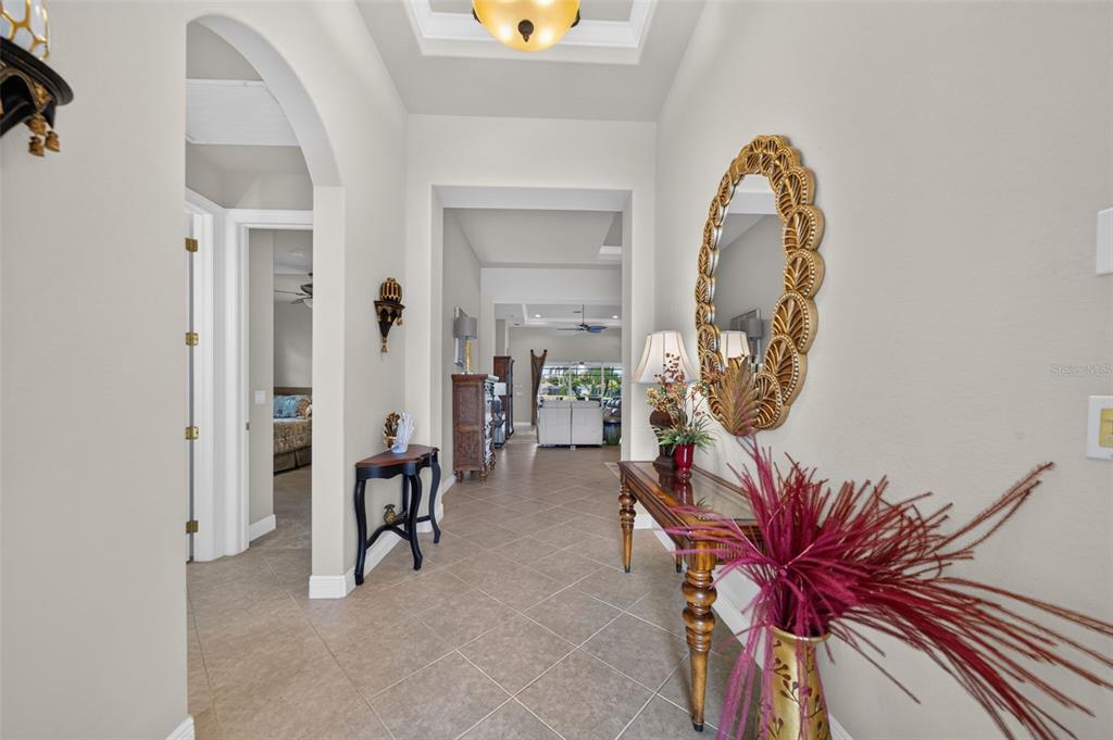 A tiled foyer features a console table, a decorative mirror, and an arched entryway — 14073 LAVANTE COURT, BONITA SPRINGS, FL