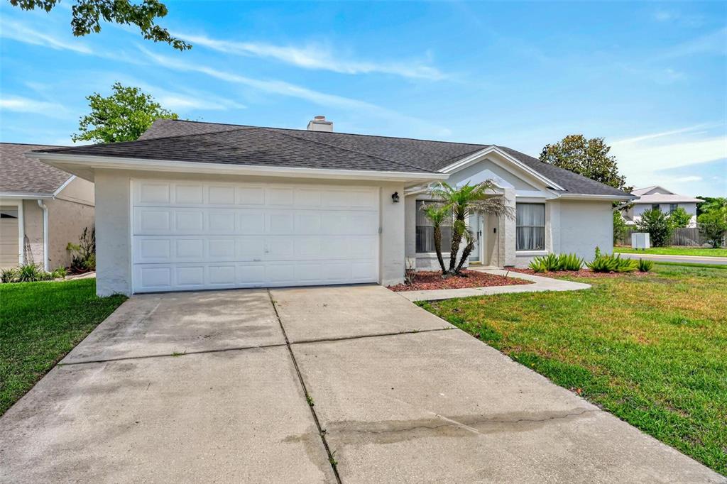 A single-story house with a white garage door, concrete driveway, and a small palm tree — 759 TOMLINSON TERRACE, LAKE MARY, FL