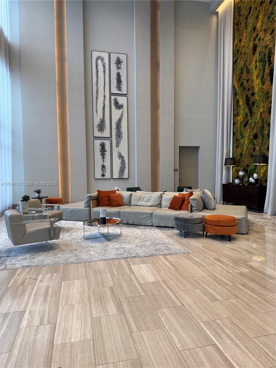 A spacious lobby features a large sectional sofa, modern art, and a vertical moss wall — 5350 NW 84th Ave # 1001, Doral FL 33166, DORAL, FL