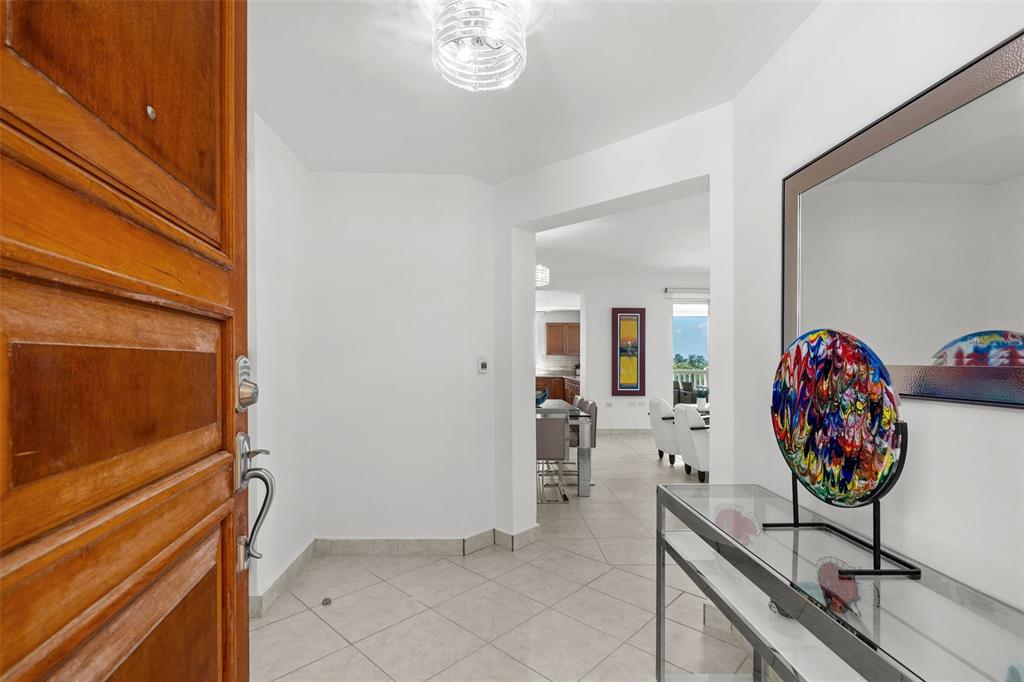 A tiled entryway leads into a dining area with a glass console table and mirror — 100 OCEAN DRIVE UNIT 144, HUMACAO, PR