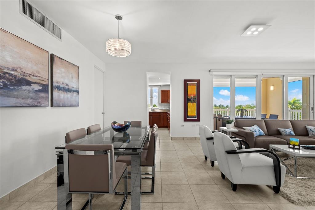 A dining area and living room with tile floors, modern furniture, and a balcony view — 100 OCEAN DRIVE UNIT 144, HUMACAO, PR