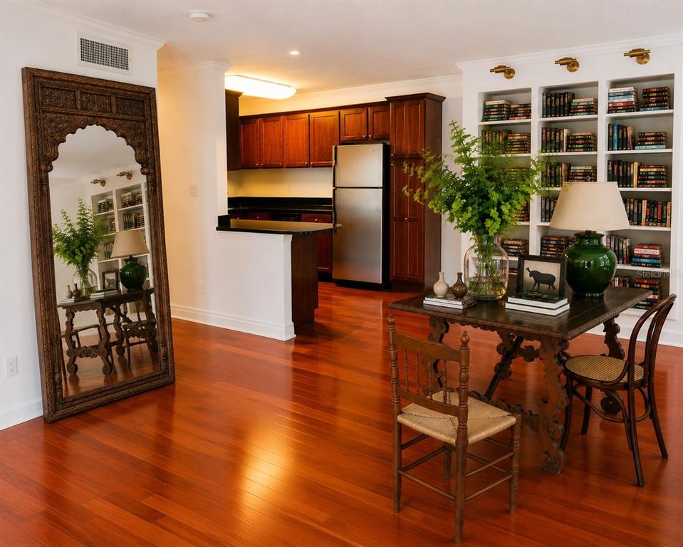 A dining area with a wooden table, chairs, and a large ornate floor mirror — 4876 CONWAY ROAD UNIT 94, ORLANDO, FL