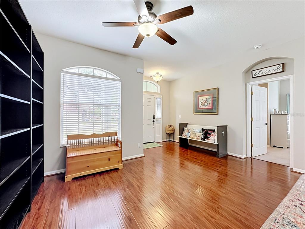 A room with hardwood floors, a ceiling fan, a window, and two wooden benches — 6161 BOBBY JONES COURT, PALMETTO, FL