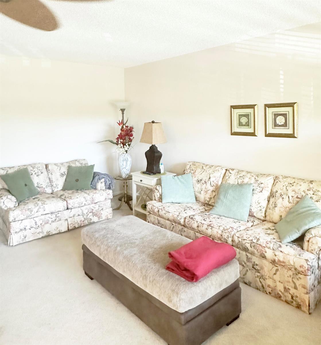 A living room features two floral sofas, a large ottoman, and a side table — 3097 Newport S # 3097, Deerfield Beach FL 33442, DEERFIELD BEACH, FL
