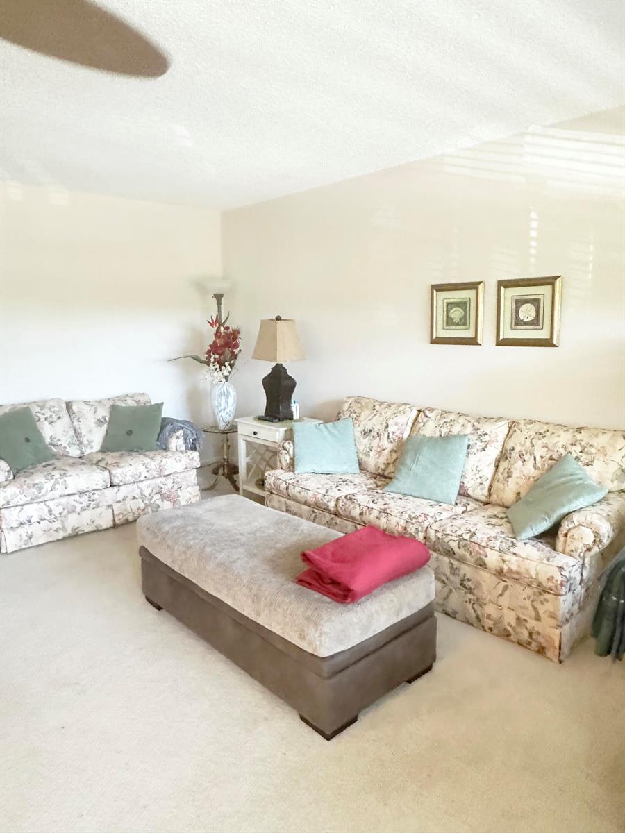 A living room features two floral sofas, a large ottoman, and two framed wall pictures — 3097 Newport S # 3097, Deerfield Beach FL 33442, DEERFIELD BEACH, FL